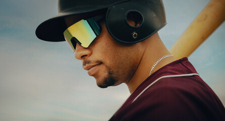 Professional baseball player wearing a uniform and helmet with sunglasses