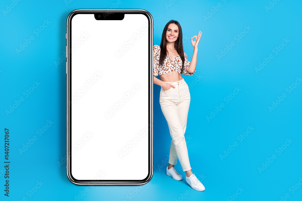 Poster full size photo of pretty young woman okey symbol empty space smart phone display isolated on blue c