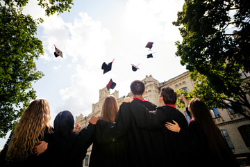 Rear photo of company groupmates students hug throw air mortarboard graduate college building...