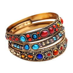 Three ornate gold bangles with colorful gemstones stacked together