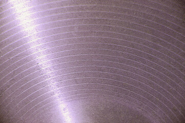 Light reflecting on a textured purple surface creating concentric circles