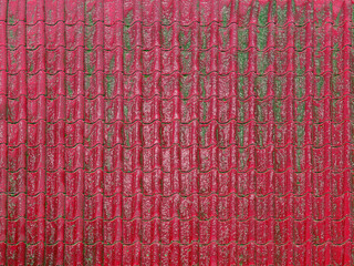 Obraz premium Red roof tiles covered with moss creating a textured background