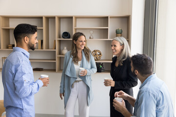 Friendly partnership. Happy joyful diverse multinational business team friends chat talk during...