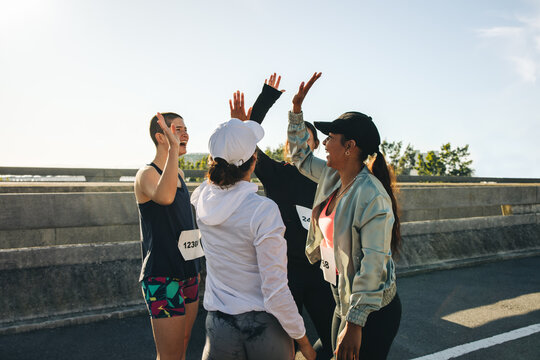 Female runners celebrating together during community race