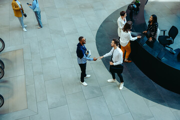 Top view of professionals greeting at a corporate reception area