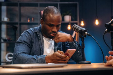 Two radio presenters recording an audio broadcast in a studio