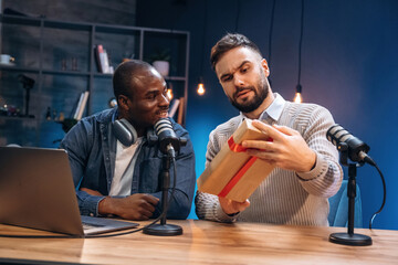 Christmas gift box. Two radio presenters recording an audio broadcast in a studio