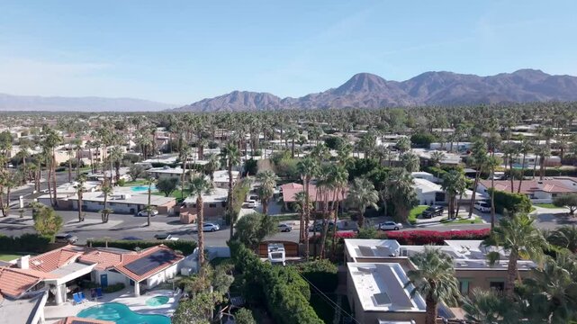 An upscale Palm Desert neighborhood with swimming pools and palm trees - aerial flyover