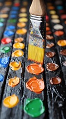 Brush hovers over colorful paint swatches; artistic inspiration, creativity, colorful, bright