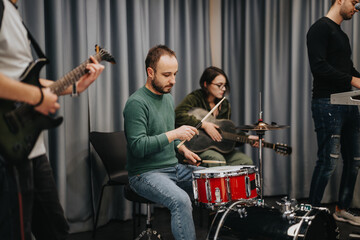 A dynamic group of young musicians engaging in a lively jam session. They are playing different...