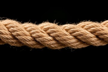 Detailed view of a thick rope highlighting its tightly woven fibers in striking monochromatic lighting, creating a strong visual contrast against a dark background