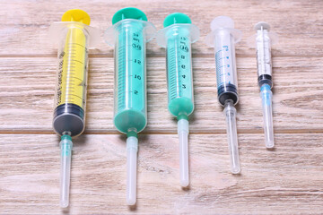 Top view of many syringes prepared for injection at wooden background. Treatment concept with copy...