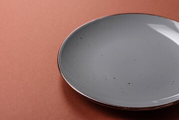 Empty ceramic plate on a monochrome brown background