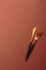 Knife and fork, cutlery on a brown dining table