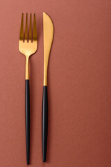 Knife and fork, cutlery on a brown dining table