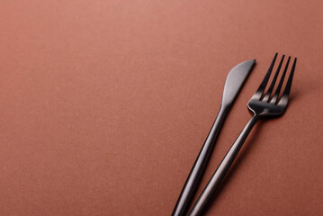 Knife and fork, cutlery on a brown dining table