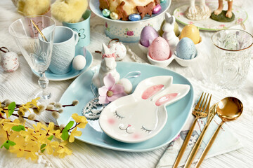 Easter table setting with blue plate and bunny shaped small plate and decors