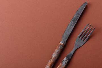 Knife and fork, cutlery on a brown dining table