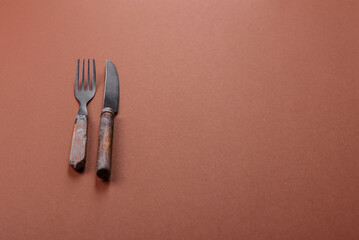 Knife and fork, cutlery on a brown dining table