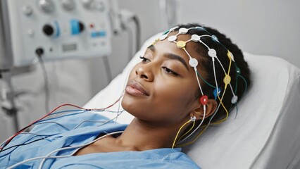A woman participates in a sleep study, wearing headbands and electrodes that monitor her brain activity.