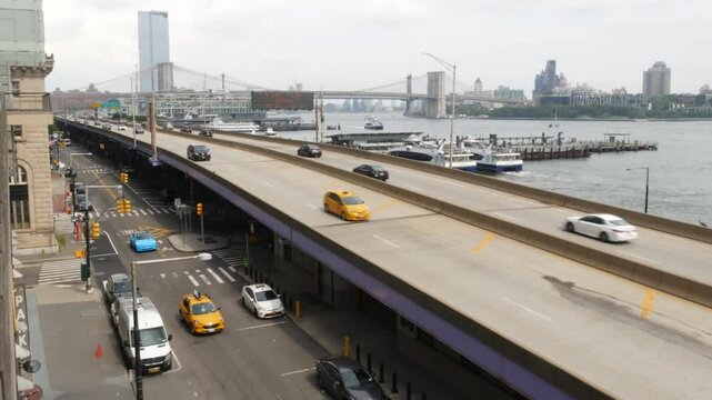 New York City waterfront road, Financial district, Manhattan Downtown riverfront from Elevated Acre. Highway along East river, cars on waterside FDR drive, yellow taxi. Brooklyn Bridge, United States.