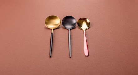 Empty metal spoon on a monochrome brown background