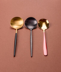 Empty metal spoon on a monochrome brown background