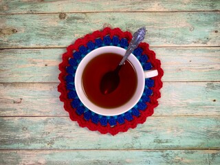Cup of tea and crocheted doily mandala photo	
