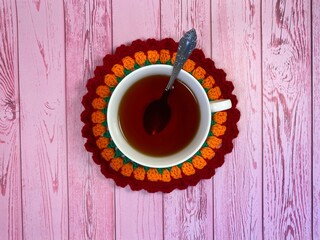 Cup of tea and crocheted doily mandala photo	
