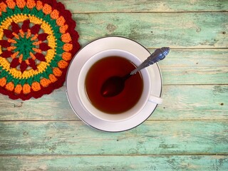 Cup of tea and crocheted doily mandala photo	
