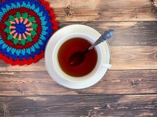 Cup of tea and crocheted doily mandala photo