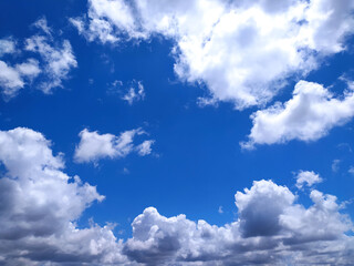 Vibrant, clear blue sky with fluffy white clouds. A beautiful, sunny day symbolizing freedom, hope, and peace. Perfect as a backdrop for travel, nature, or motivational concepts.
