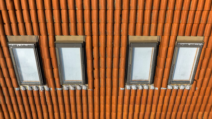 Aerial view of 4 small windows on the roof of a building.