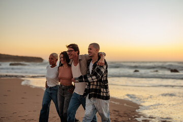 Friends walking on beach at sunset, enjoying summer vacation