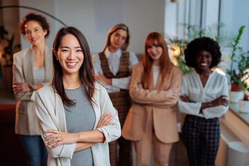 Happy businesswoman posing in front of her colleagues