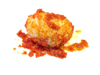 Closeup of a whole boiled egg coated with spicy red balado sauce, isolated on white background