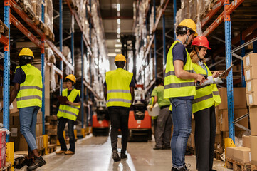 Warehouse workers managing inventory and logistics with digital tablet and scanner