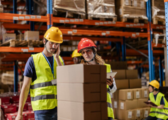 Warehouse workers checking inventory using digital tablet and phone