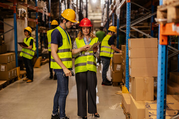 Warehouse workers using digital tablet and barcode scanner for inventory management