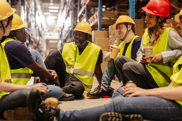 Warehouse workers relaxing on break, enjoying conversation and coffee