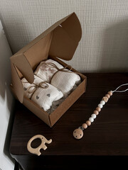 A box of muslin diapers, beads, and a wooden elephant teether are on the bedside table. Fashionable...