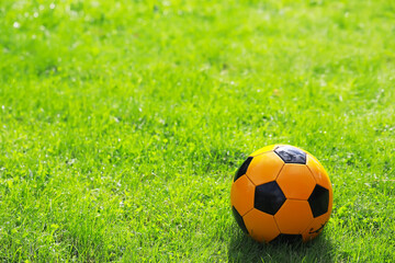 Bright Yellow Soccer Ball on Lush Green Grass in Sunny Outdoor Field