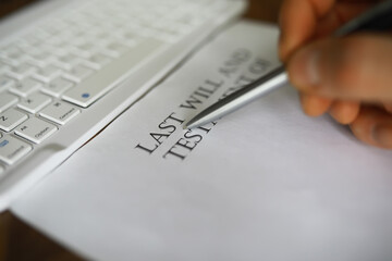 Signing Last Will and Testament Document Near Computer Keyboard