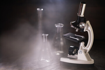 Vintage Microscope and Laboratory Glassware Amidst Smoky Ambience in Classic Scientific Setting