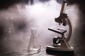 Scientific Microscope with Erlenmeyer Flask and Mysterious Smoke in Laboratory Setting