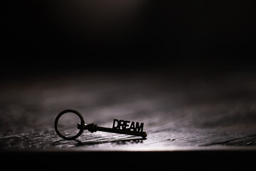 Key with DREAM Word on Dimly Lit Wooden Surface, Symbolizing Aspirations and Possibilities