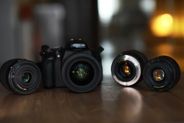 Professional DSLR Camera with Interchangeable Lenses on Wooden Surface in Soft Focus Background