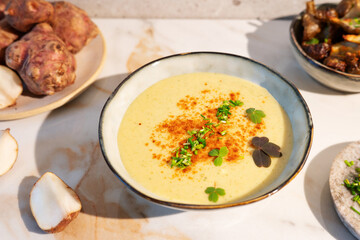 Jerusalem artichoke puree soup, beautifully plated with fresh ingredients.