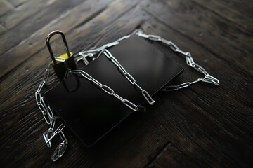 Securing Digital Devices with Chains and Padlock on Rustic Wooden Surface - Cybersecurity and Data...