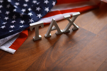 American Tax Concept with Flag Background on Wooden Surface